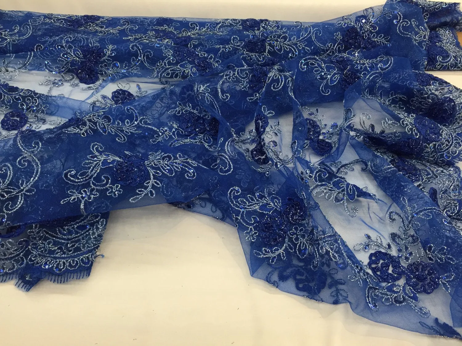 Royal blue 3d flowers embroider with sequins on a mesh lace fabric. Sold by the yard.